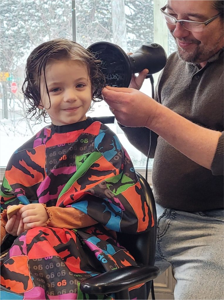 little girl at salon getting hair dried with diffuser after child's haircut with Norbie